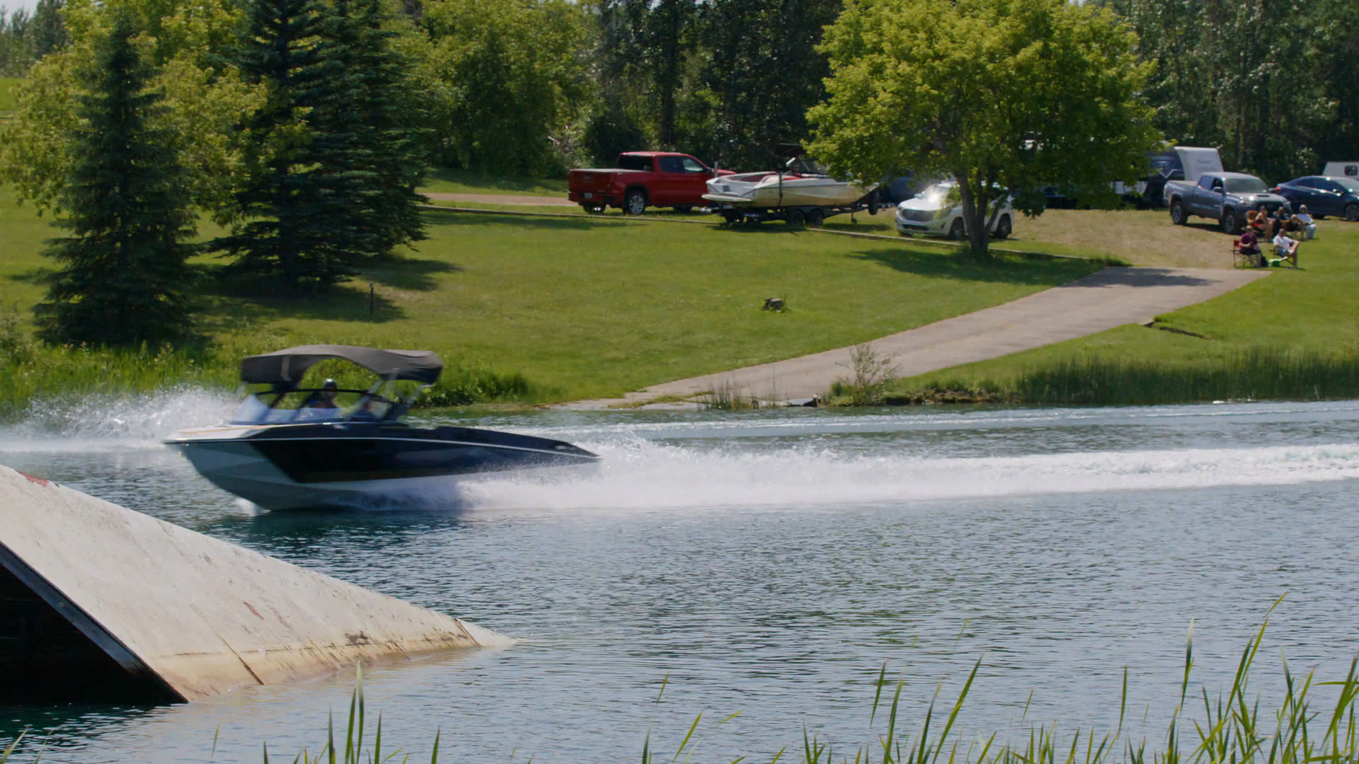 Ski boat pulling a jumper toward the ramp at Shalom Park's private competition lake