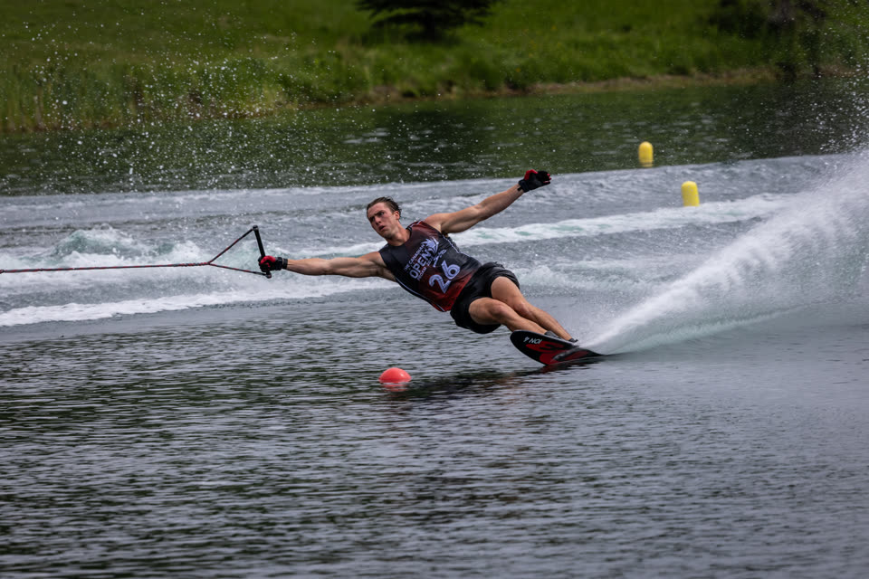Skier laid out around the buoy with twin plumes of spray